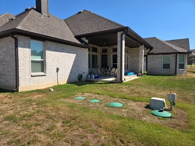 Dark seamless gutter system around a covered backyard patio