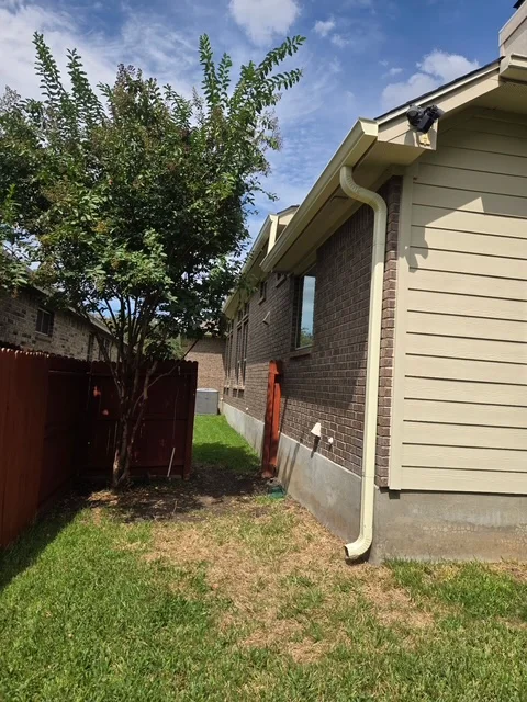 White gutter and downspout fitted to a rear home addition