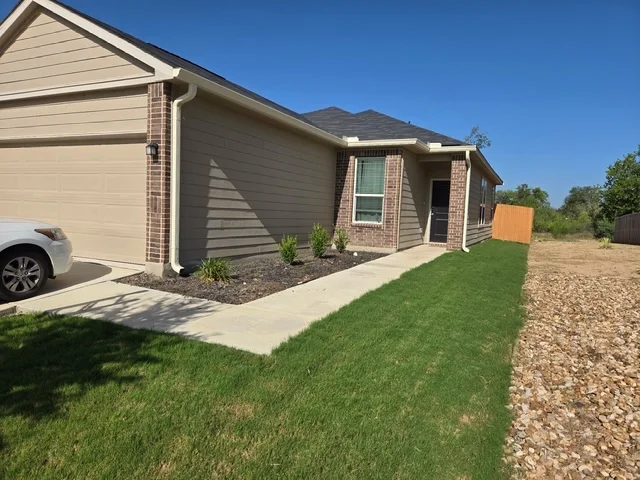 White gutter and downspout installed along a front roofline