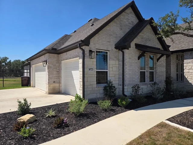Dark gutters and downspouts installed on a finished front elevation